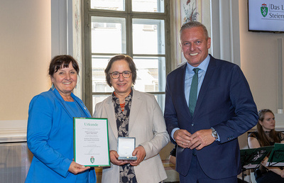 Landeshauptmann Maria Kunasek und Stellvertreterin Manuela Khom überreichen das goldene Ehrenzeichen des Landes Steiermark an Agens Truger.